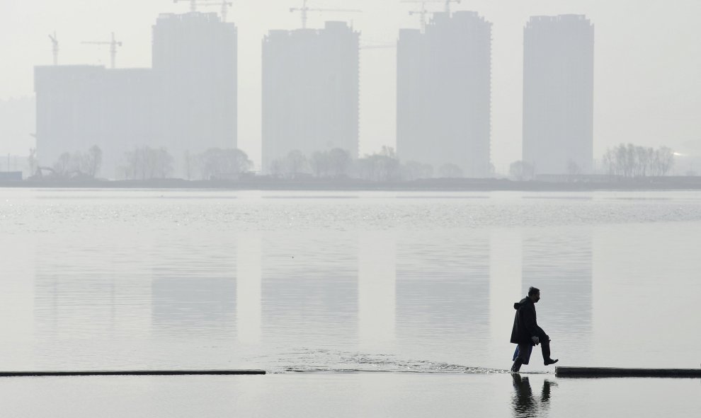 Un hombre camina por un lago artificial en Taiyuan, provincia de Shanxi, China. REUTERS/Jon Woo