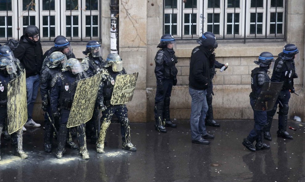 La policía antidisturbios francesa protegerse detrás de escudos durante una manifestación de estudiantes de instituto y universitarios franceses en contra de la propuesta de la legislación laboral francés en París. REUTERS