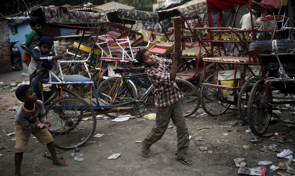 Los niños juegan al críquet frente a los rickshaws estacionados en el casco antiguo de Delhi, India 31 de marzo de 2016. REUTERS / Anindito Mukherjee