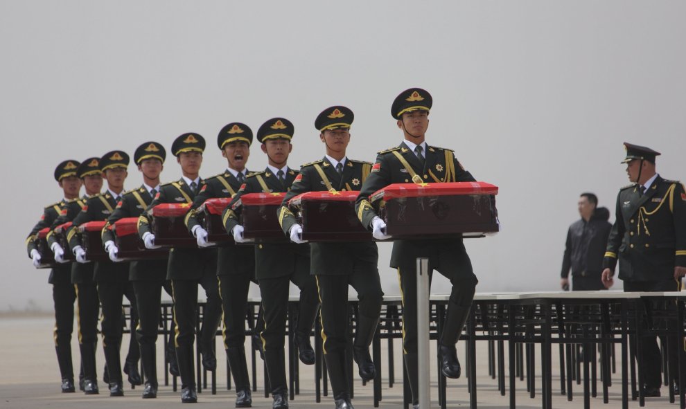 Guardias de honor chinos llevan ataúdes devueltos por Corea del Sur que contienen los restos de los soldados chinos que murieron durante la Guerra de Corea de 1950-53, en un aeropuerto de Shenyang, provincia de Liaoning, 31 de marzo de 2016. REUTERS / Str