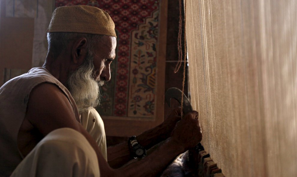 Un tejedor de alfombras tradicionales trabaja en un telar artesanal en un taller en las afueras de Karachi, Pakistan. REUTERS/Akhtar Soomro