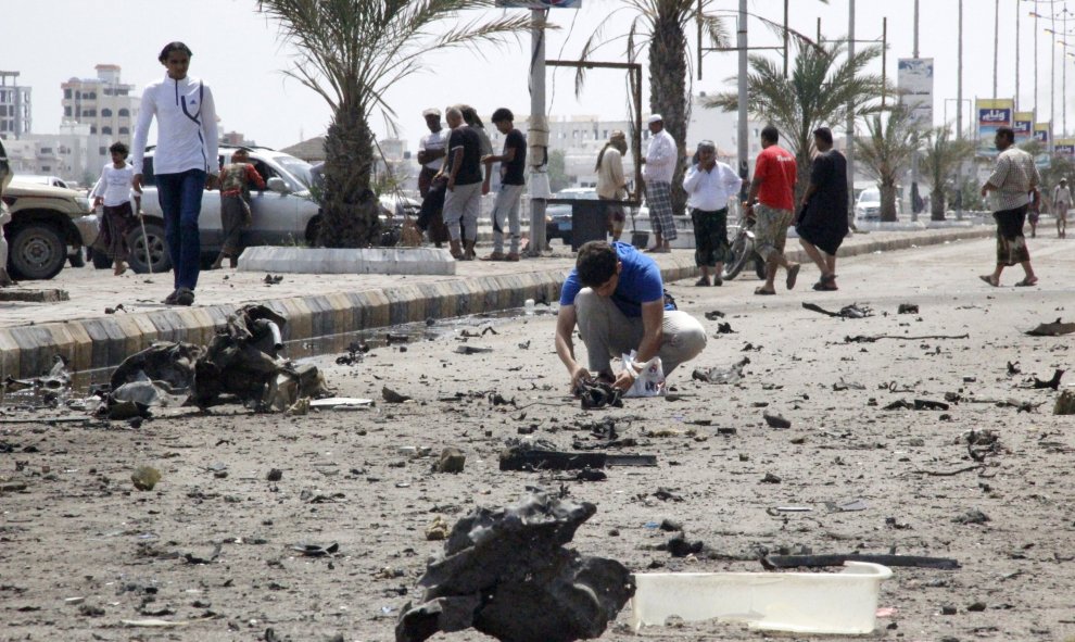 Un hombre registra los restos tras un ataque con coche bomba frente al Ministerio de Asuntos Exteriores en la ciudad yemení de Adén. REUTERS/Fawaz Salman