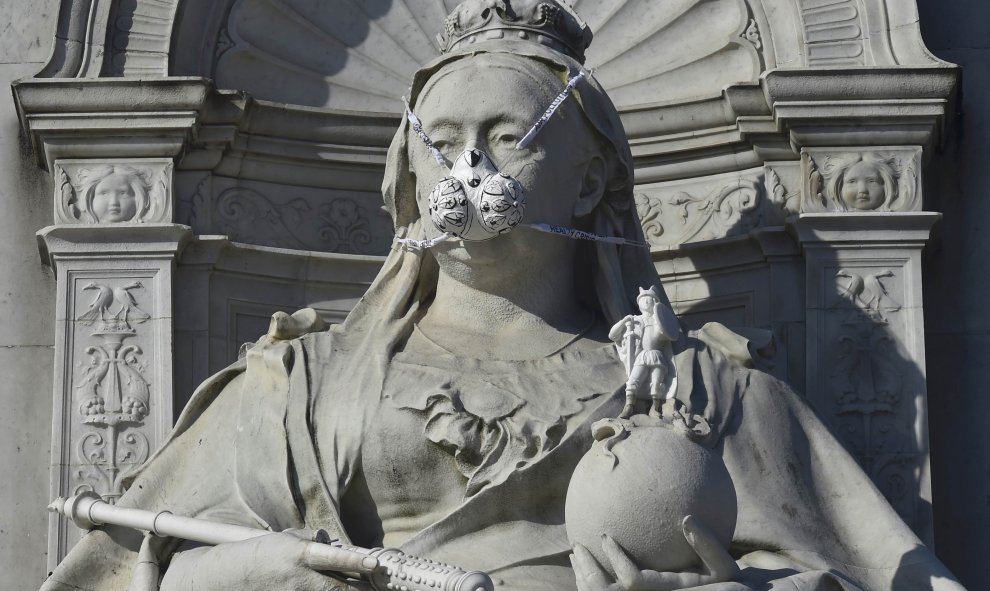 Una representación de una máscara de gas colocada por el grupo ecologista Greenpeace en una estatua de la reina Victoria de Inglaterra, cerca de Buckingham Palace en Londres. REUTERS/Toby Melville