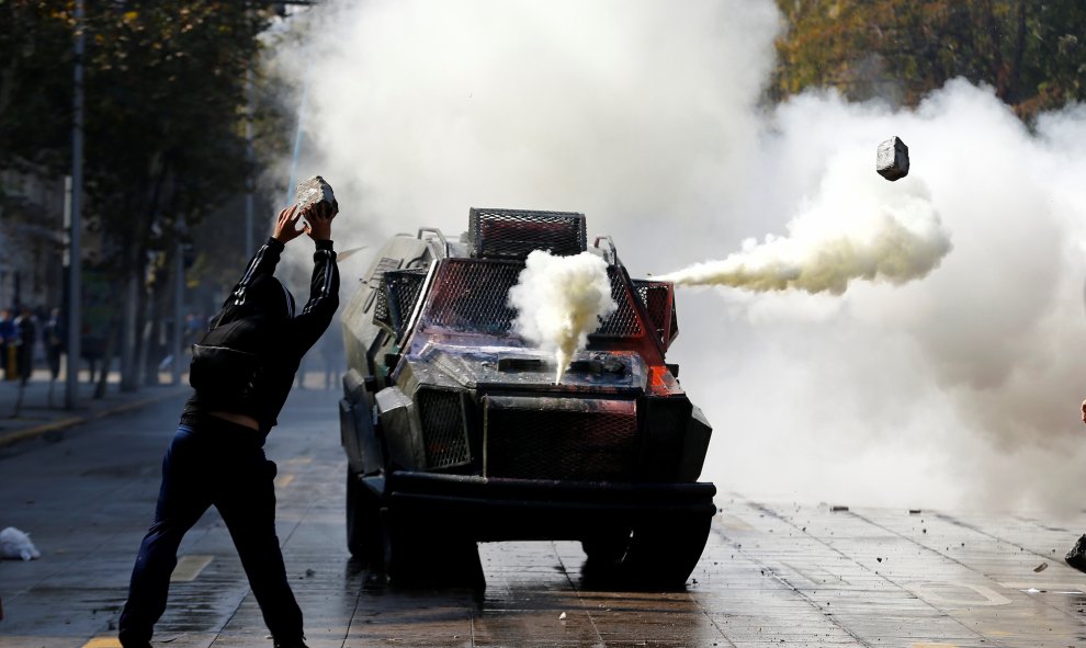 Un estudiante chileno protesta delante de un vehículo policial por la reforma de la educación. Santiago, Chile. REUTERS/Ivan Alvarado