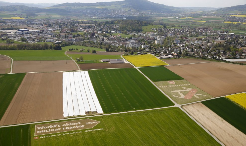 Vista aérea de un cartel gigante que muestra la distancia a la planta suiza nuclear de Beznau, la más antigua que operan en el mundo, colocado por el grupo de protesta ecologista Greenpeace en un campo cercano al aeropuerto de Zurich, cerca de Niederglatt