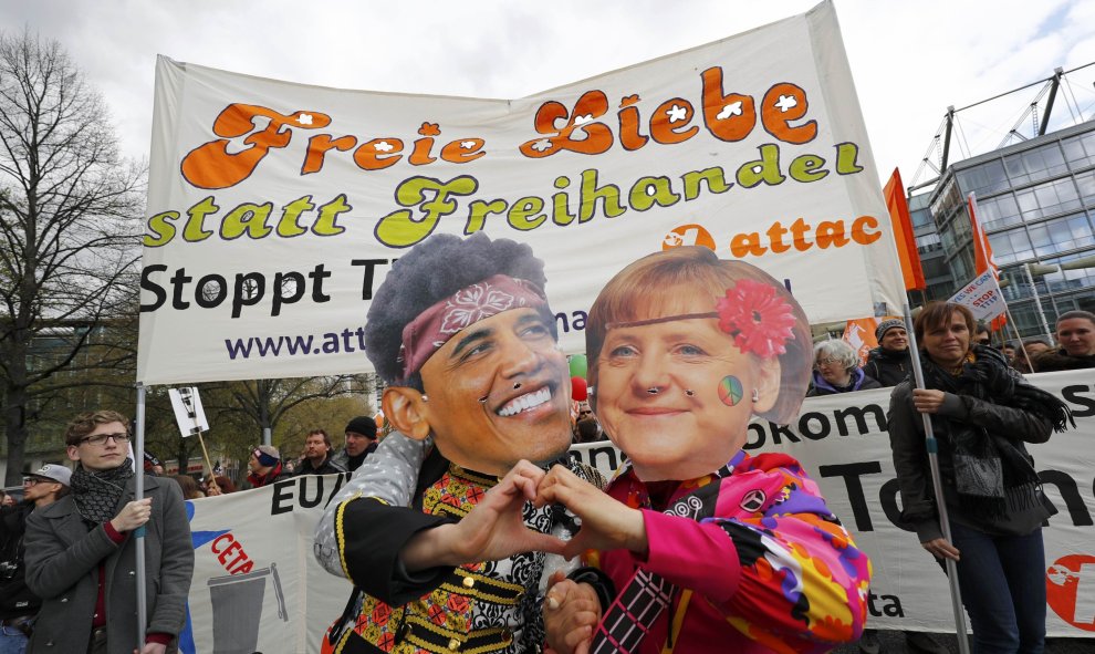 Dos manifestantes se disfrazan de Obama y Merkel, en protesta contra el tratado comercial entre EEUU y la Unión Europea. REUTERS/Kai Pfaffenbach