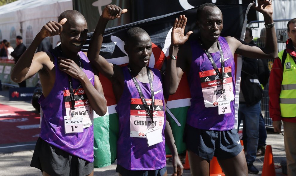 El atleta keniano Peter Kiplagat (i), ganador de la 39 Maratón Popular de Madrid con un tiempo de 2:11:44, acompañado del segundo y tercer clasificados, los también kenianos Patrick Cheruiyot (c) y Alfhonce Kibiwot Kigen, tras llegar a la meta de la carre