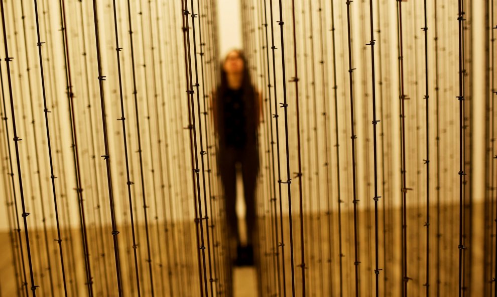 Una trabajadora del museo posa entre la obra 'Impenetrable, 2009', un trabajo de Mona Hatoun previo a su exhibición en el Tate Modern de Londres, Inglaterra. REUTERS/Dylan Martinez