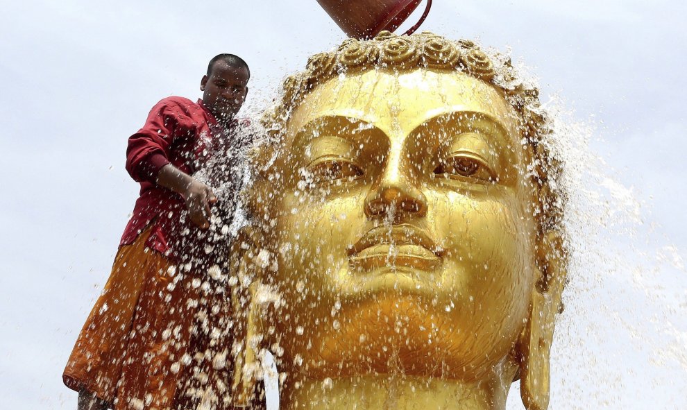 Un monje budista limpia una estatua de Buda de cara a las celebraciones de su cumpleaños en un monasterio de Bhopal. EFE/Sanjeev Gupta