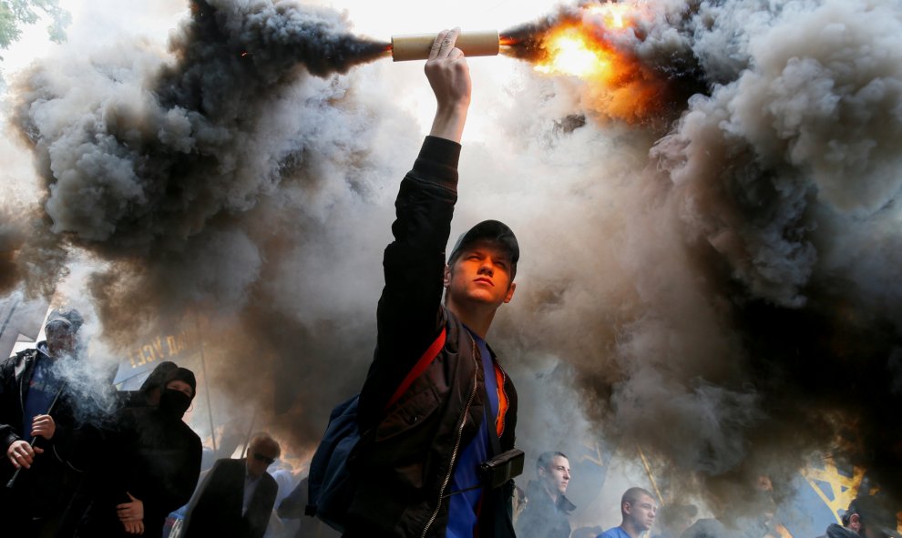 Simpatizantes de diferentes movimientos de extrema derecha queman bengalas durante una protesta en el centro de Kiev, Ucrania. REUTERS/Gleb Garanich