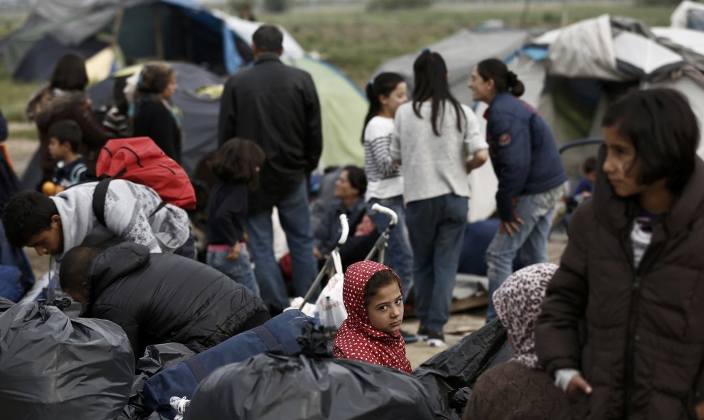 Una familia de refugiados espera a ser trasladada durante el desalojo policial campo de Idimeni, en la frontera entre Gracia y Macedonia. REUTERS/Yannis Kolesidis