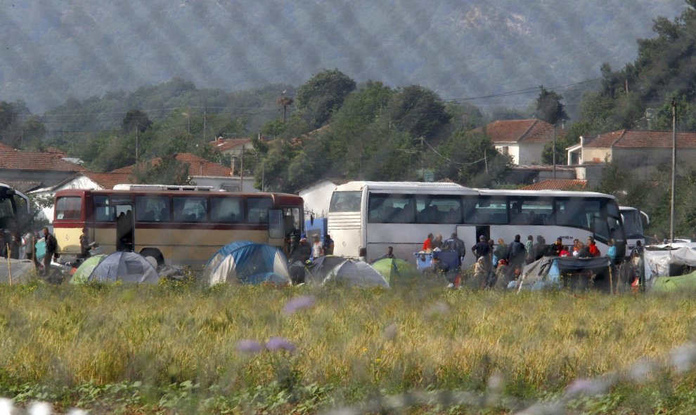Refugiados suben al autobus que les traslada a un centro de acogida tras el desalojo policial del campo de Idomeni, en la frontera greco-macedonia. REUTERS/Ognen Teofilovski