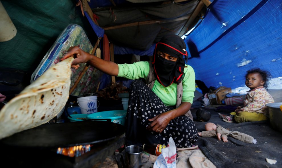 Una mujer hace pan en su tienda de campaña situada en Sanaa, Yemen. REUTERS/Khaled Abdullah