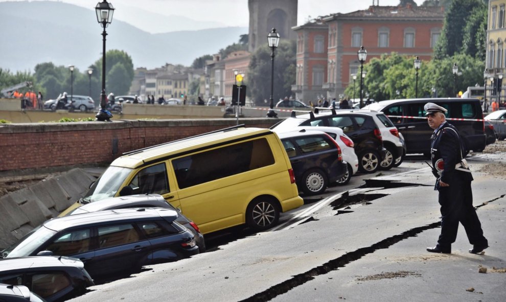 Varios vehículos aparecen engullidos por un socavón cerca del famoso Puente Viejo a orillas del río Arno, en el centro de la ciudad italiana de Florencia (Italia). EFE/Maurizio Degl' Innocenti