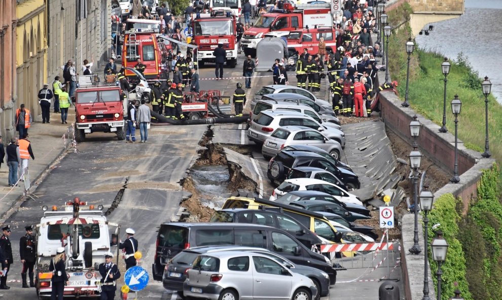 Varios vehículos aparecen engullidos por un socavón cerca del famoso Puente Viejo a orillas del río Arno, en el centro de la ciudad italiana de Florencia (Italia). EFE/Maurizio Degl' Innocenti