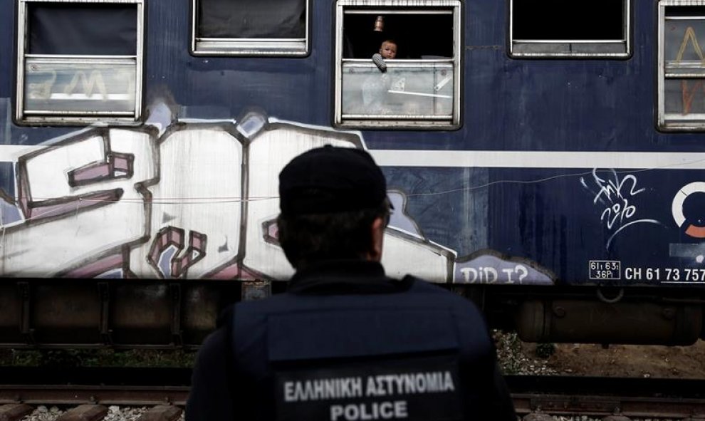 Un niño se asoma a la ventana de un vagón de tren durante una operación para desalojar el campamento improvisado de Idomeni, en Greci. EFE/Yannis Kolesidis