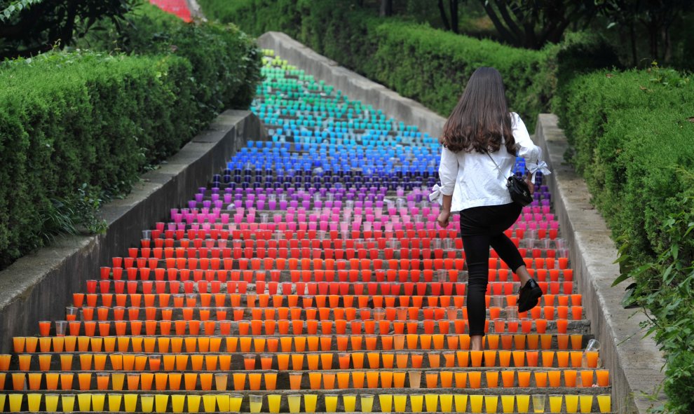 Un mujer sube por unas escaleras realizadas con vasos de plástico, una obra de arte de cuatro estudiantes en Wuhan, provincia de Hubei, China. REUTERS/Stringer