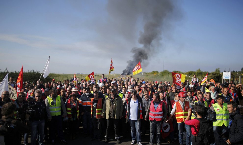Miembros de un sindicato francés en huelga se reúnen cerca de una barricada de fuego que bloquea la entrada del depósito de la empresa SFDM cerca de la refinería de petróleo, contra la propuesta de ley de reforma laboral en Donges , Francia.-  REUTERS / S