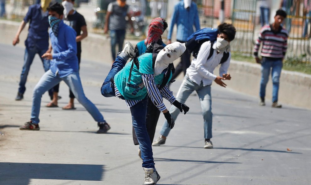 En Cachemira manifestantes enmascarados tiran piedras hacia el personal de seguridad de la India durante una manifestación contra el plan para reubicar a los hindúes en la ciudad , .- REUTERS / Danish Ismail