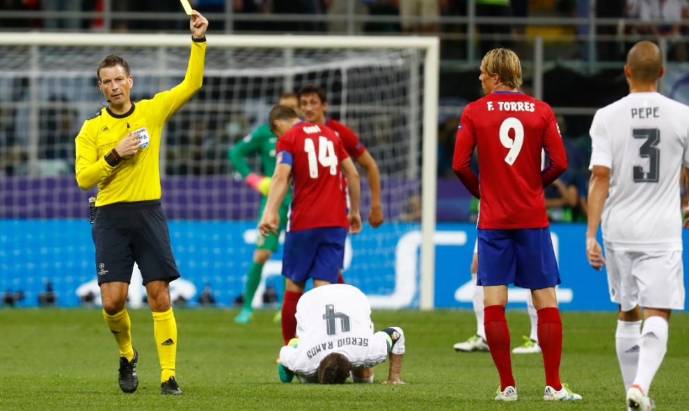 El árbitro enseña la tarjeta amarilla a Fernando Torres por su falta a Sergio Ramos. REUTERS/ Kai Pfaffenbach