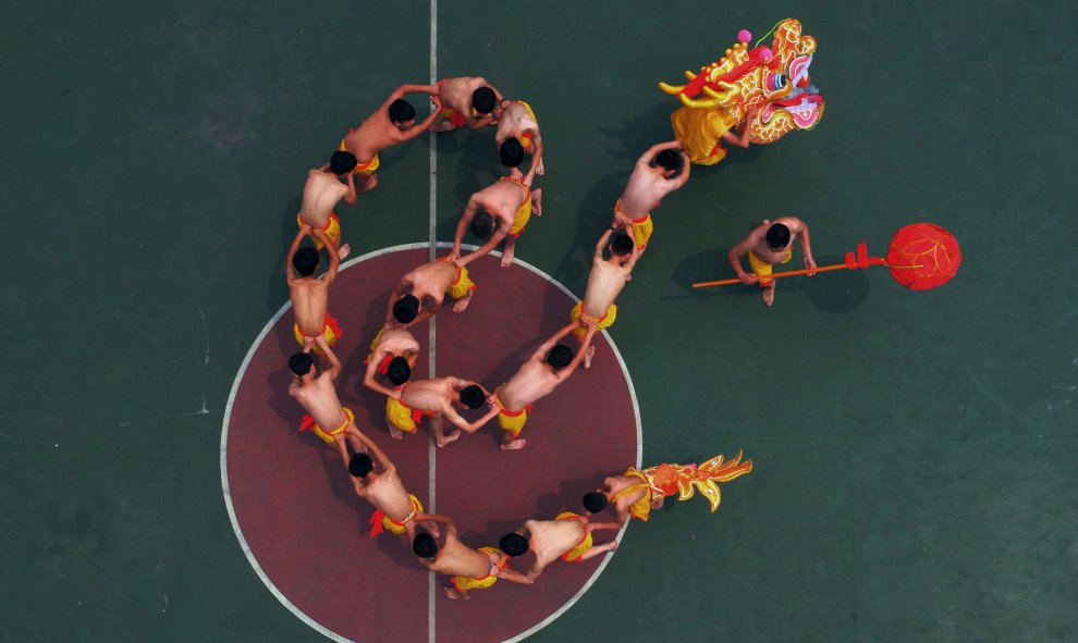 Unos estudiantes ensayan la coreografía de un dragón bajo la dirección de un artista para una actuación de Chongqing, China. REUTERS/Stringer