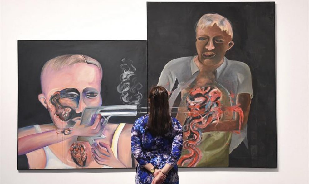 Una trabajadora del museo observa la obra 'Bullet Shot in the Stomach', del artista indio Bhupen Khakhar, durante la presentación a la prensa de la exposición 'You Can't Please All' en el museo Tate Modern de Londres, Reino Unido. EFE/Facundo Arrizabalaga
