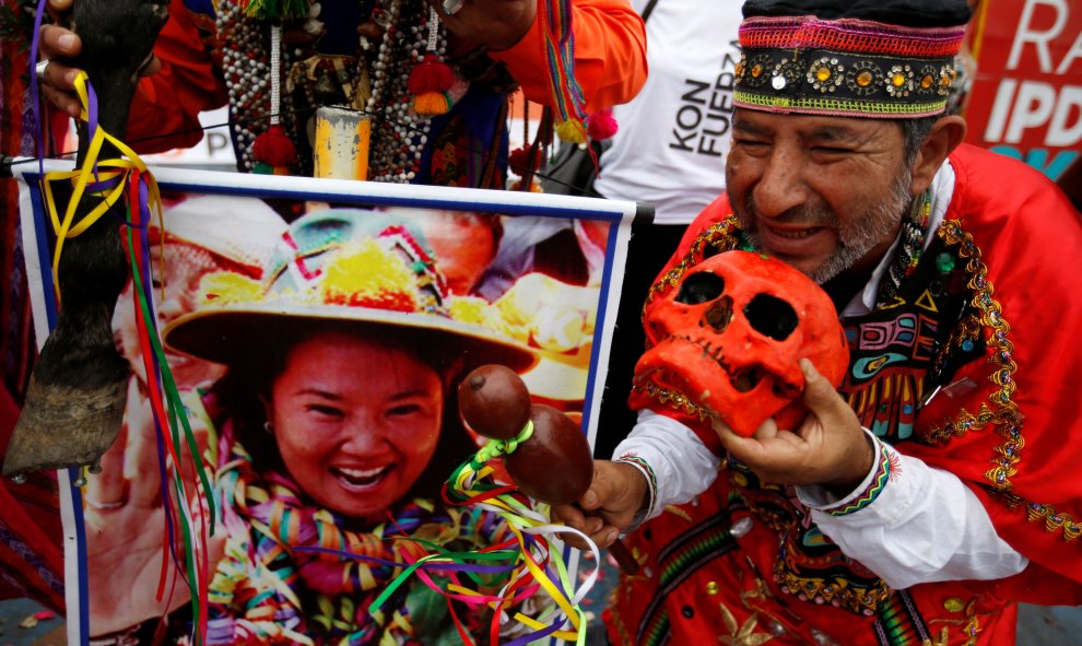 Un chamán peruano realiza un ritual de predicciones antes de las elecciones del país con el cartel de la candidata presidencial Keiko Fujimori. Lima, Perú. REUTERS/Mariana Bazo