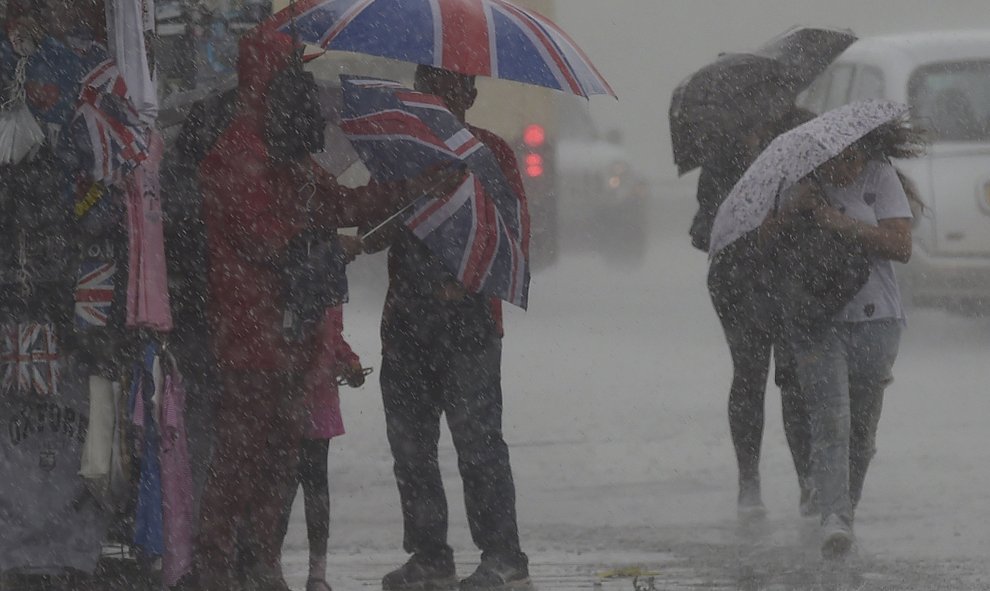 Ciudadanos se protegen de la intensa lluvia de Londres, Reino Unido. REUTERS/Toby Melville