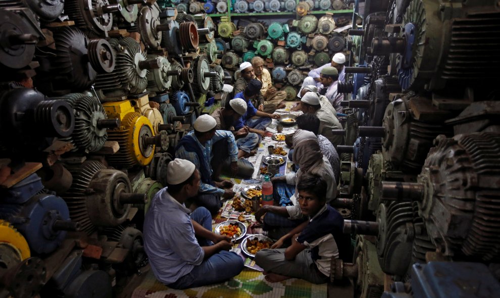 Un grupo de musulmanes comen su iftar durante el Ramadan en un taller en Delhi, India. REUTERS/Adnan Abidi