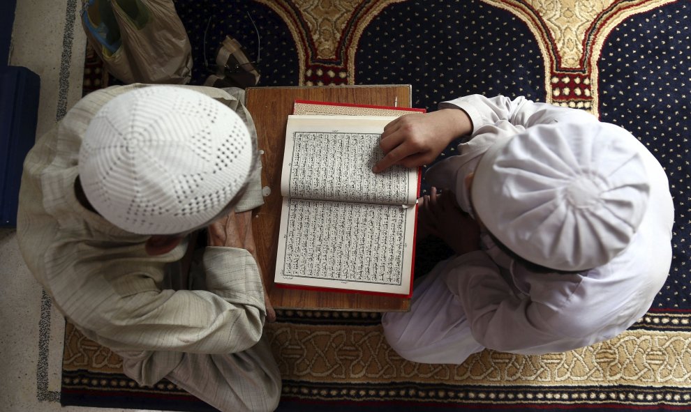 Dos niños leen el Corán en una mezquita durante la celebración del mes del Ramadán en Karachi, Pakistán. EFE/Rehan Khan