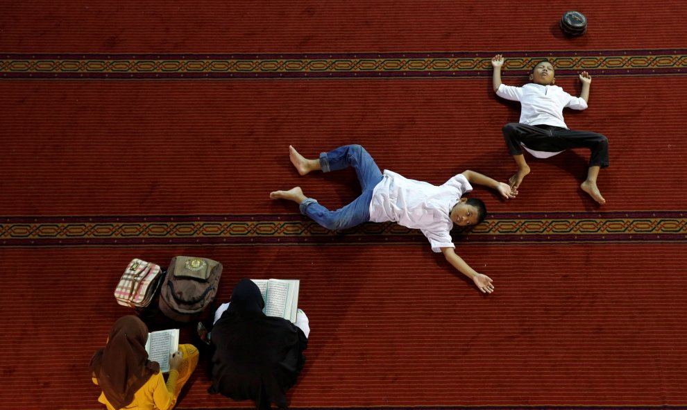 Mujeres leen el Corán mientras los niños descansan dentro de la mezquita Istiqlal durante el Ramadán en Jakarta, Indonesia. REUTERS/Beawiharta