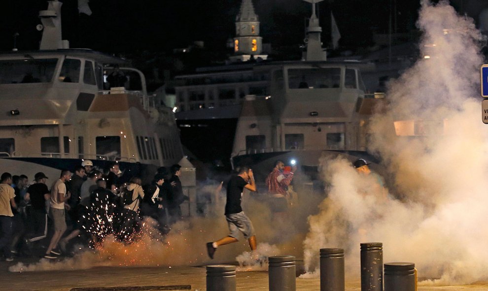 Ultras en el puerto de Marsella lanzando bengalas y botes de humo anoche tras el Inglaterra-Rusia. /REUTERS