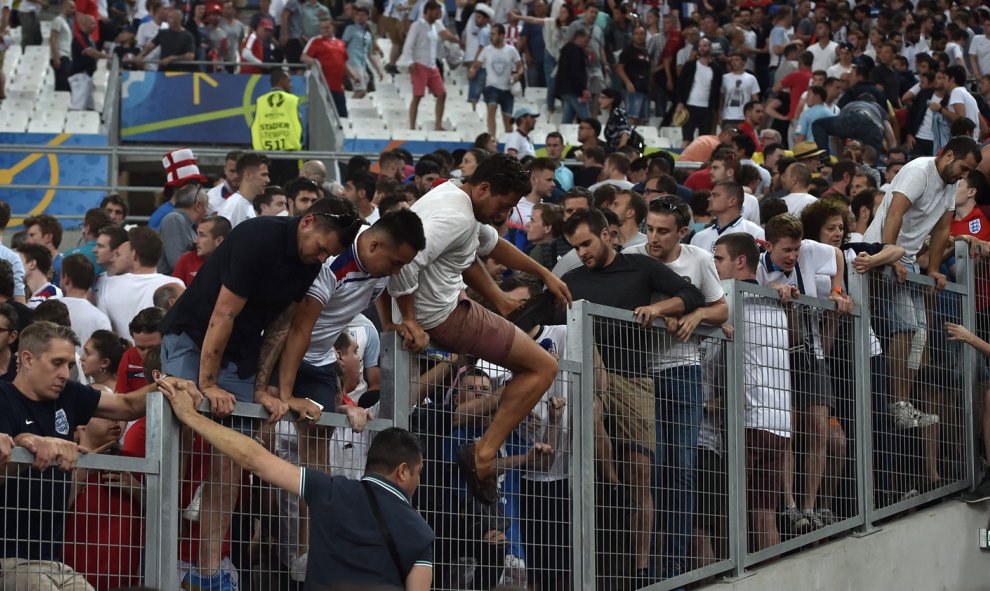 Ultras ingleses saltan una valla para huir de la zona de disturbios en las gradas del Vélodrome. /EFE