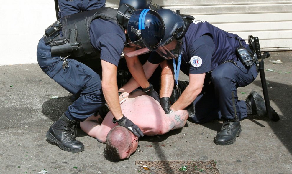 Un ultra sometido en el suelo por tres agentes antidisturbios en Marsella. /REUTERS