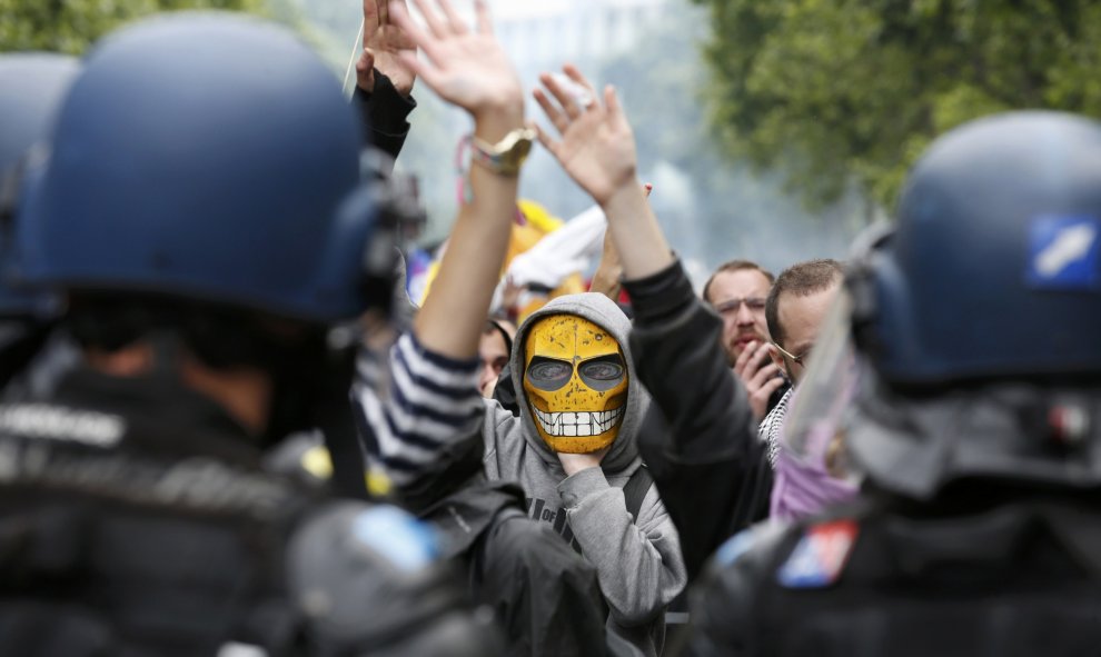 Un joven enmascarado reacciona frente a los gendarmes franceses durante una manifestación en París contra la reforma laboral del Gobierno de Hollande. REUTERS/Philippe Wojazer