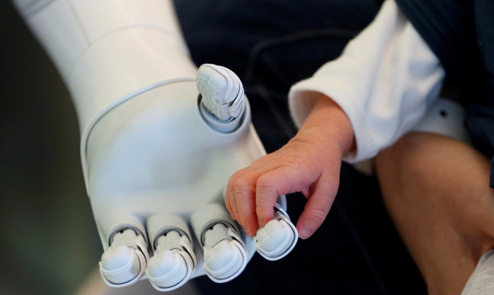 El robot humanoide Pepper, diseñado para dar la bienvenida y cuidar de visitantes y pacientes, sujeta la mano de un recién nacido en el hospital AZ Damiaan en Ostend, Bélgica. REUTERS/Francois Lenoir