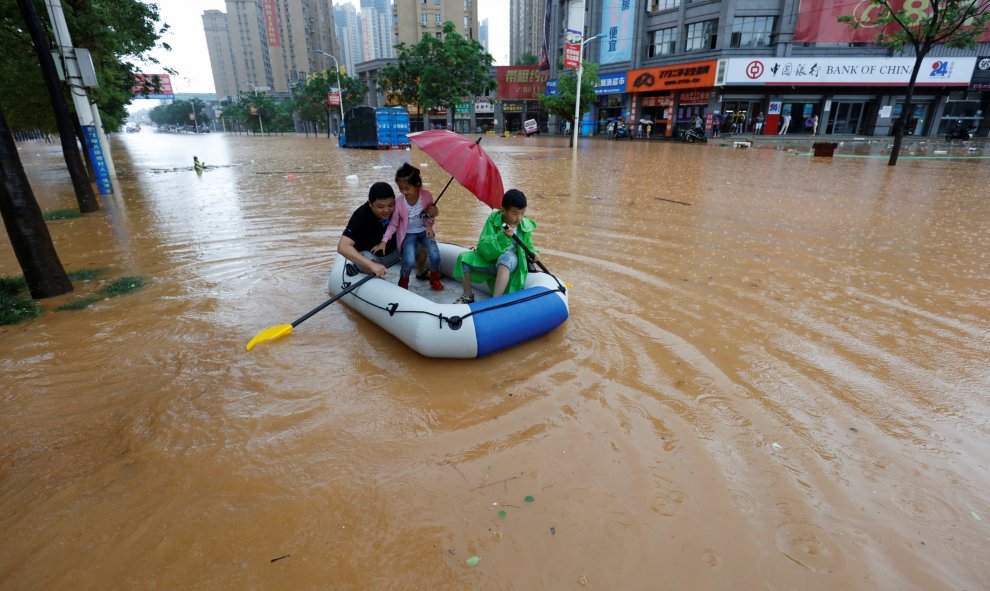 Unos ciudadanos utilizan un bote inflable para moverse en la zona inundada de Jiujiang en la provincia de Jiangxi, China. REUTERS/Stringer