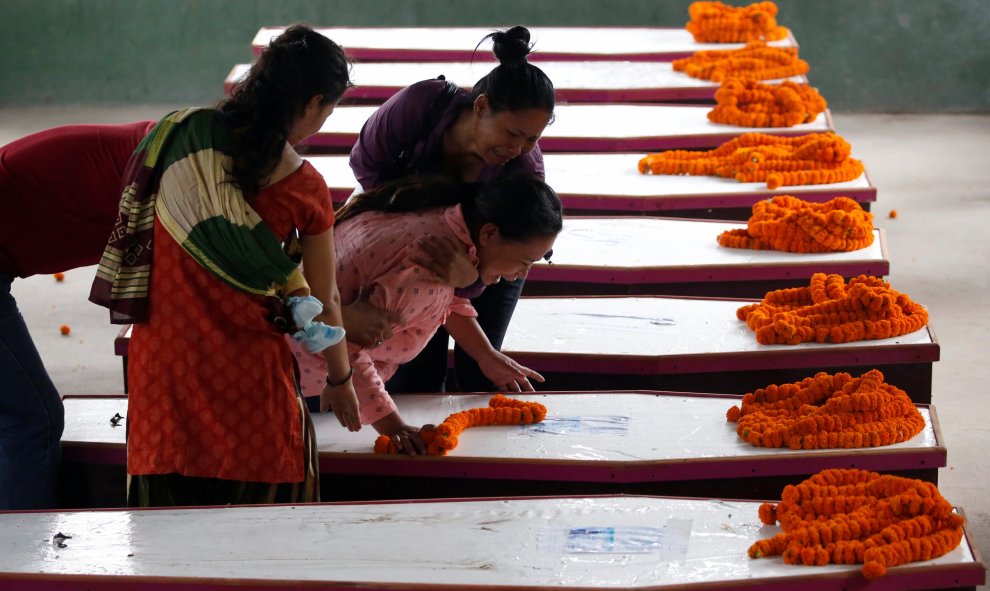 Los familiares lloran cerca de ataúdes que contienen los cuerpos de los nacionales de Nepal , que murieron cuando bombardero suicida hizo minibús en Kabul , en fila después de haber volado desde Afganistán en el aeropuerto internacional de Tribhuvan en Ka