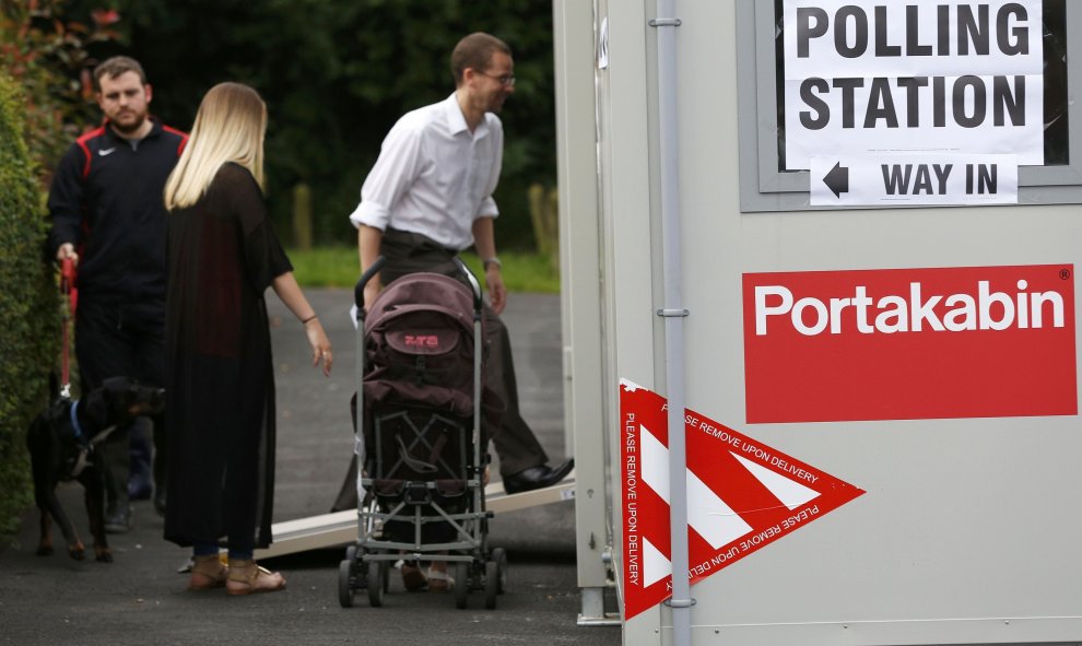 Tres personas acuden a votar a uno de los puntos móviles de votación en Reino Unido/REUTERS
