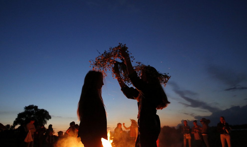 Jóvenes bielorrusas se colocan adornos florales con motivo de la celebración de la Noche de Iván Kupala a orillas del río Pripyat river en Turov, Bielorrusia. EFE/TATYANA ZENKOVICH