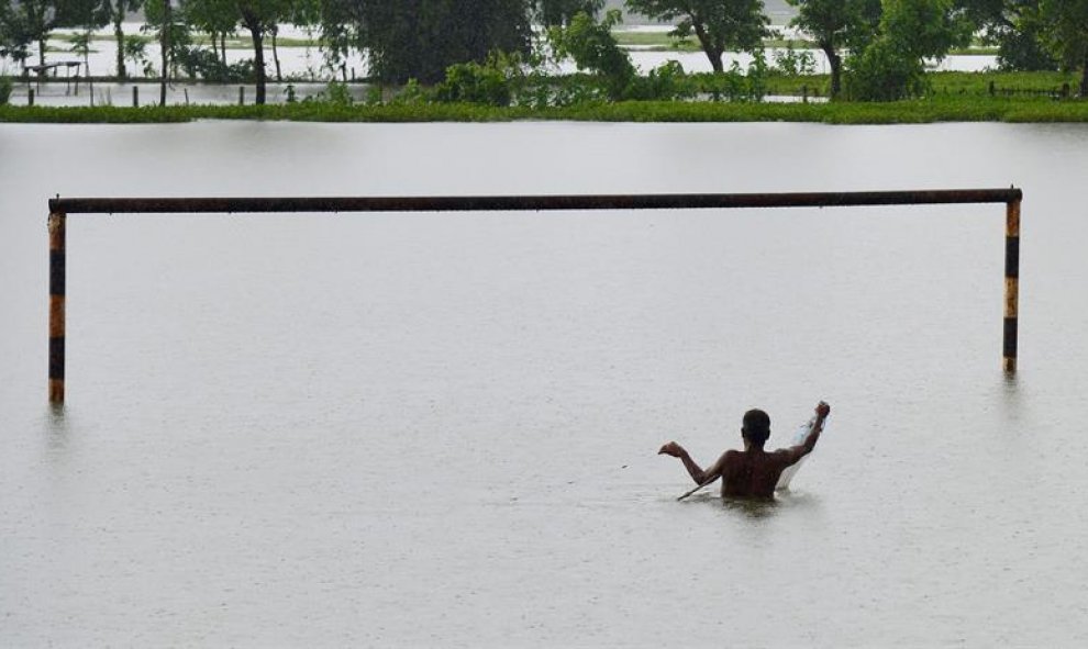 Un hombre pesca en un parque inundado del distrito de Morigaon, estado de Assam, India, el 8 de julio del 2016. Las continuas lluvias han inundado seis distritos de Assam. EFE/Str