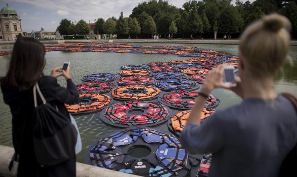 Dos mujeres toman fotos de la obra "F Lotus" del artista chino Ai Weiwei en los jardines del Palacio Belvedere durante la presentación a la prensa de la exposición "AI WEIWEI traslocación-transformación"en Viena (Austria). EFE/Christian Bruna