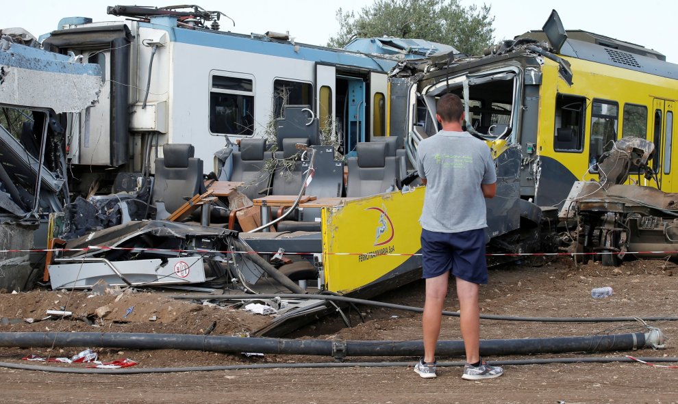Un hombre mira los restos en el lugar donde dos trenes de pasajeros chocaron en medio de un olivar en la localidad meridional de Corato , cerca de Bari , Italia.- REUTERS