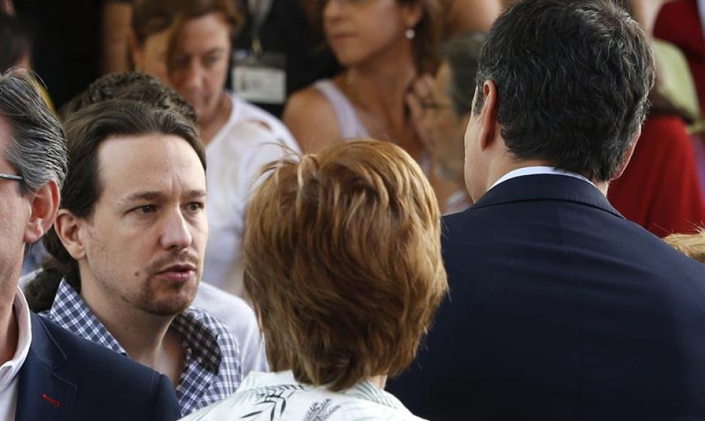 El líder de Podemos, Pablo Iglesias (i), se dirige al secretario general socialista, Pedro Sánchez (d), tras guardar hoy un minuto de silencio en memoria de las víctimas del atentado perpetrado anoche Niza, en el Congreso de los Diputados.- EFE/J. J. Guil