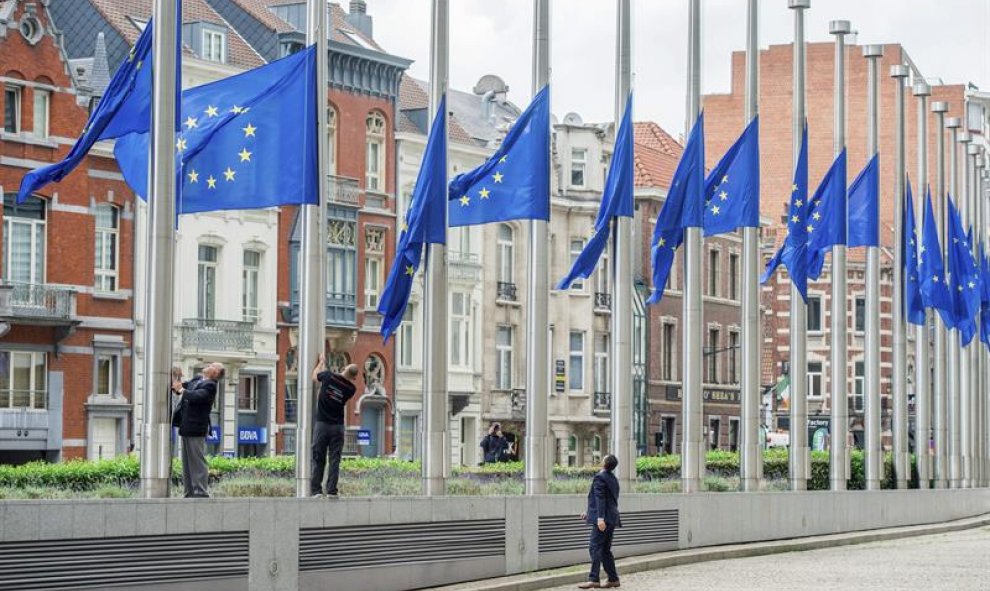 Varios operarios izan las banderas de la Unión Europea a media asta delante del edificio de la Comisión Europea en honor a las victimas del atentado en Niza ocurrido durante el día de la Bastilla, en Bruselas, Bélgica, hoy, 15 de julio de 2016. Al menos 8