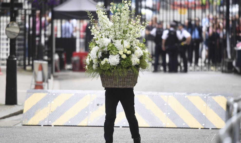 Un hombre lleva flores al número 10 de Downing Street. REUTERS/Toby Melville