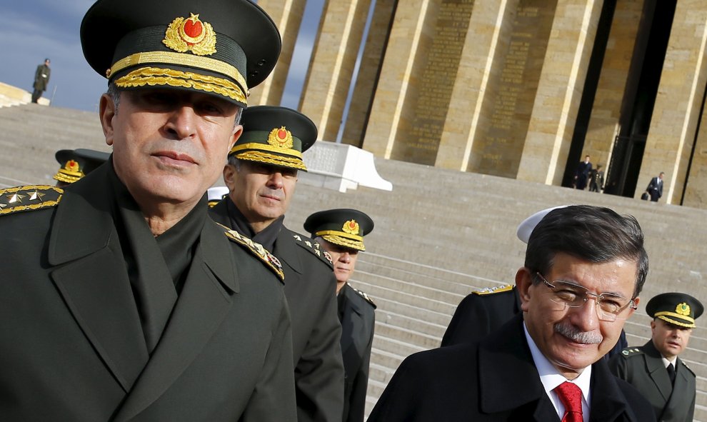 El primer ministro turco Ahmet Davutoglu (der), flanqueado por general jefe del Ejército turco Hulusi Akar (izq) y algunos de los principales mandos militares de las Fuerzas Armadas del país, en una imagen de archivo. REUTERS/Umit Bektas/