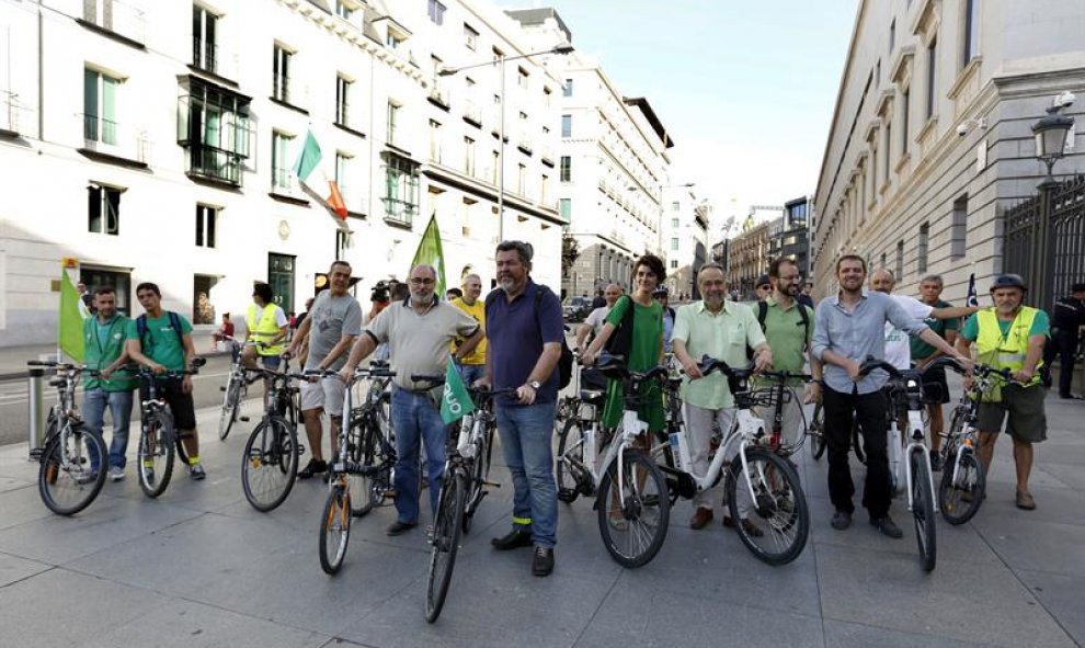 Integrantes de Equo, con Juantxo López de Uralde (c) a la cabeza, llegan en bicicleta al Congreso para asistir a la sesión constitutiva de las Cortes Generales de la XII legislatura. /EFE