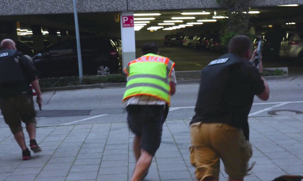 Una captura de pantalla de un vídeo muestra a policías con ropa de calle en el aparcamiento del centro comercial Olympia. REUTERS/Marc Mueller