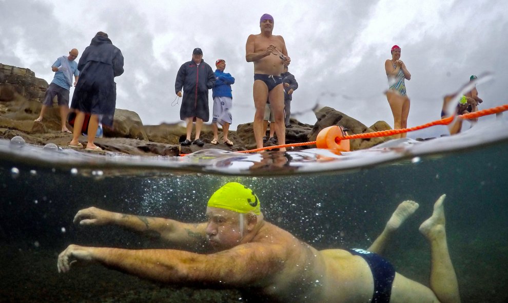 Un miembro del club de natación Maroubra Winter Seals se prepara para saltar a una piscina natural mientras un compañero nada por debajo de él en la playa de Maroubra en Sydney, Australia. REUTERS/David Gray